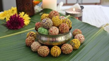A bowl filled with colorful candy on a banana leaf photo