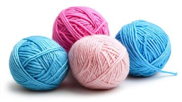 Four colorful yarn balls in pink and blue shades on white background photo