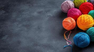 Colorful yarn balls with loose ends on dark textured surface photo