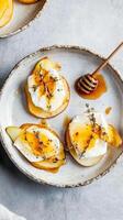 canapés coronado con dulce Pera rebanadas y cremoso queso Brie queso rociado con miel y hierbas para un delicioso aperitivo foto