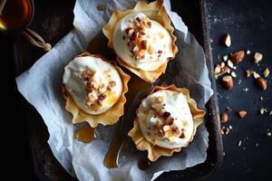 Delicious tartlets filled with Greek yogurt and topped with nuts and honey on a rustic serving tray photo