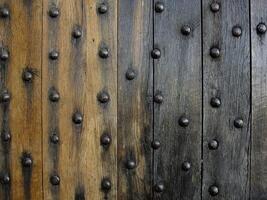 Texture and patterns of aged wooden door with decorative metal studs photo