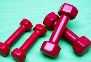 small dumbbells on green background photo