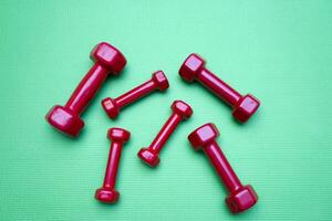small dumbbells on green background photo