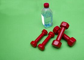 small dumbbells on green background photo