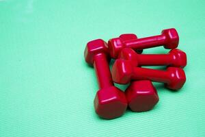 small dumbbells on green background photo