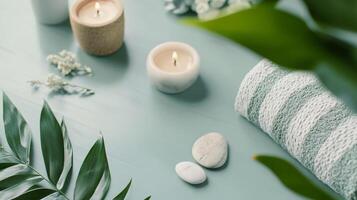 Burning candles and towel creating relaxing spa ambiance on light blue table photo