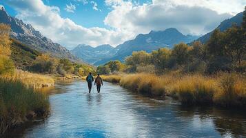 A couple of people walking across a river photo