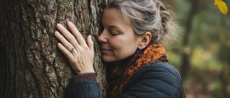 A serene woman embraces a tree, symbolizing a deep connection with nature and tranquility in a peaceful outdoor setting. photo