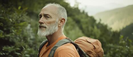A rugged, older man with a beard stands in nature, wearing an orange shirt and carrying a backpack, exuding a sense of adventure and exploration. photo