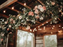 A beautifully decorated indoor space featuring floral arrangements and warm string lights, creating a cozy and inviting atmosphere. photo