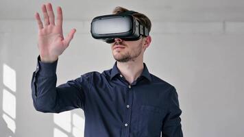 Man wearing a virtual reality headset interacts with a digital environment in a bright modern space video