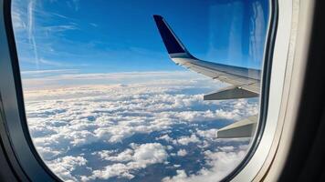 View from airplane window showing the aircraft wing above a sea of clouds video