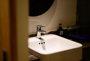 Faucet washbasin in the bathroom in the hotel photo