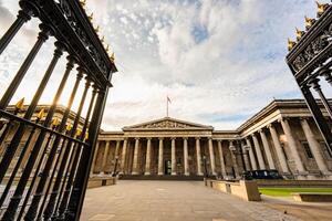 The British Museum grand neoclassical facade in London features towering columns and symmetrical design, standing proudly under an expansive sky. photo