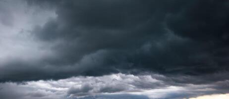 The dark sky with heavy cloud converging and a violent storm before the rain.Bad or moody weather sky and environment. carbon dioxide emissions, greenhouse effect, global warming, climate change photo