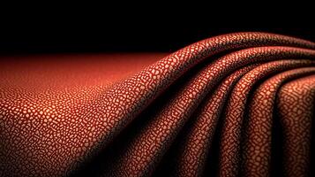 Close-up of textured red fabric with intricate patterns, softly draped against a dark background photo