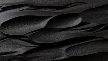 Close-up of textured black surface with flowing patterns resembling natural formations photo