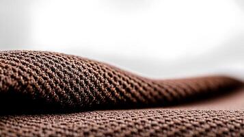 Close-up of textured brown fabric draped softly, creating gentle waves against a light background photo