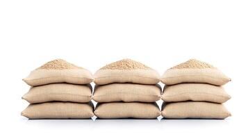 Stacked burlap sacks filled with grains on a clean white background, showcasing agricultural produce photo