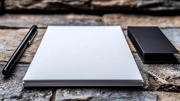 A blank notepad and pen on a textured stone surface, ideal for creative brainstorming sessions photo