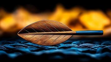 A beautifully crafted wooden leaf-shaped spoon resting on a textured surface with flames in the background photo