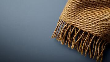 Close-up of a textured brown scarf draped on a smooth blue surface, highlighting its fibers photo