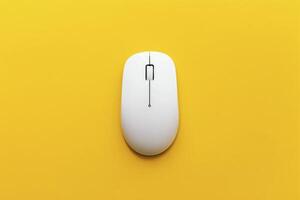 A white computer mouse on a yellow background photo