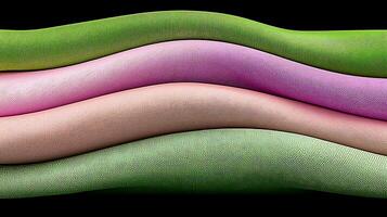 Colorful, textured fabric rolls stacked in waves, showcasing vibrant hues against a dark background photo
