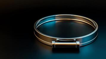 Sleek metallic bracelet resting on a dark surface, illuminated by soft blue and silver light photo