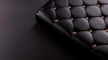Close-up of a textured black leather surface with decorative golden buttons on a dark background photo