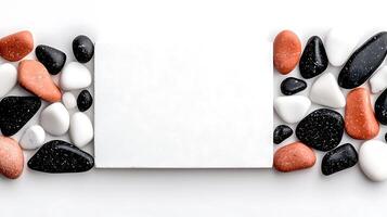 A minimalistic composition featuring smooth pebbles surrounding a blank white card on a clean surface photo
