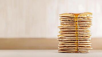Stack of golden pancakes drizzled with syrup on a wooden table, showcasing breakfast delight photo