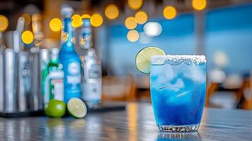 Refreshing blue cocktail with lime slice on a bar table, surrounded by blurred bottles and lights photo