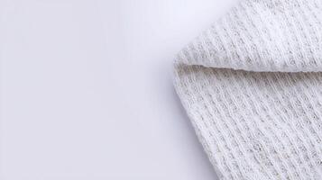 Close-up of a textured white fabric corner on a light background, showcasing its intricate weave photo