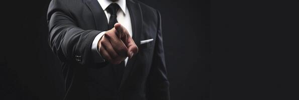 A man in a suit and tie is pointing at something photo