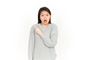 A woman is pointing her finger up and making a surprised face photo
