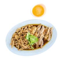 Chop boiled duck and stew intestine in brown soy soup dipping spicy sauce, focus selective photo