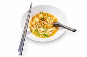 Top view of Spicy TOM YAM pork noodle soup with lemongrass chilly pasted and lime juice, focus selective photo