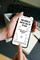 Mobile Phone Mockup in Hand Showing a Clean Interface on a Desk psd