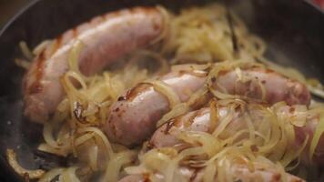 Anonymous cook adding soy sauce into pan with onion and sausages video