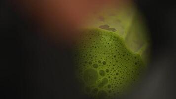 Crop person removing lid from blender filed with green smoothie video
