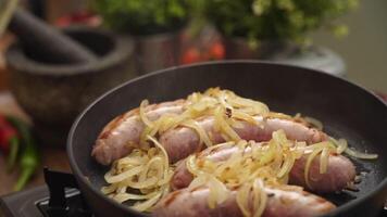 Anonymous cook adding onion into pan with sausages video