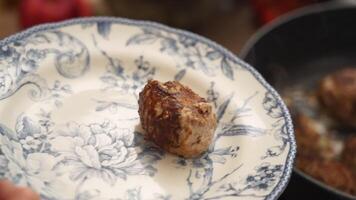 Crop cook putting cutlets on plate video