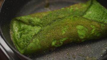 Anonymous cook removing lid from frying pan with spinach omelette video