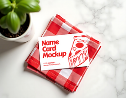 A name card mockup featuring a pizza slice rests on a red gingham napkin psd