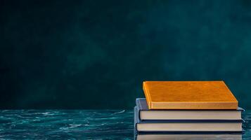 Stacked books on a marble surface with a textured teal background, ideal for educational themes photo