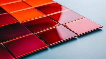 Close-up of glossy red tiles arranged in a geometric pattern on a smooth surface photo
