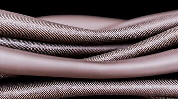 Close-up of intricately woven fabric showcasing smooth, flowing textures against a dark background photo