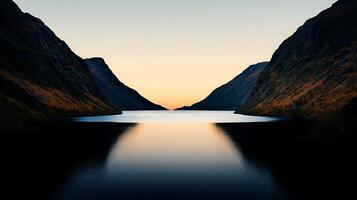 Serene twilight over a tranquil lake surrounded by majestic mountains and fading light photo